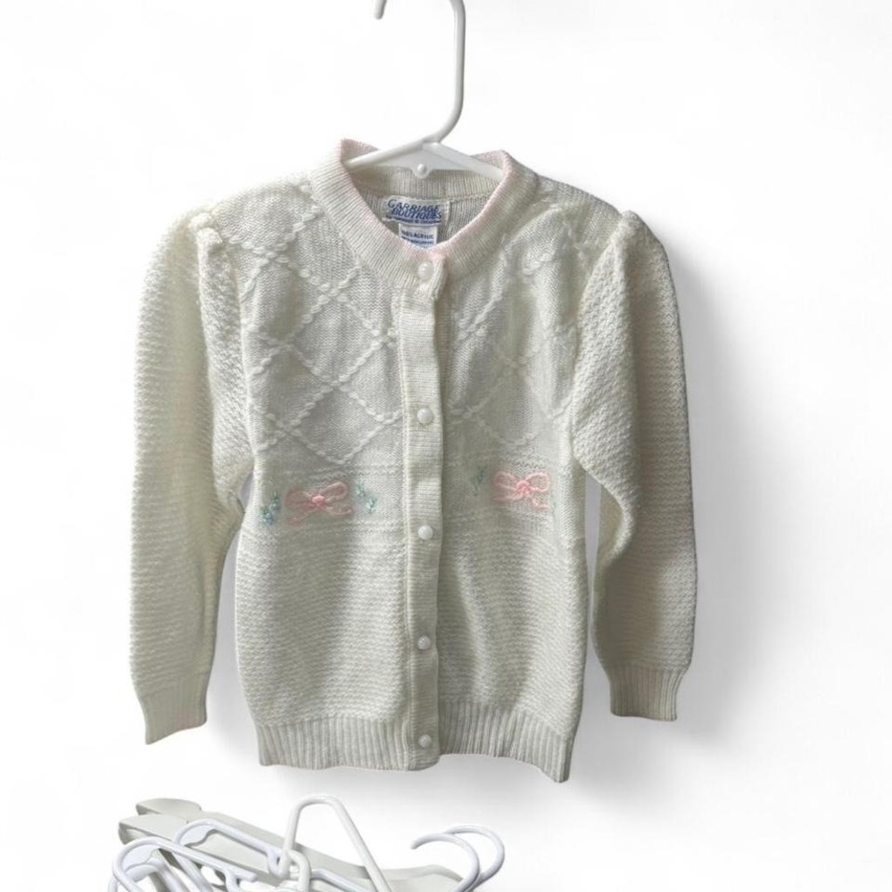 Adorable baby pink and white knit cardigan with bows and pink ribbon details